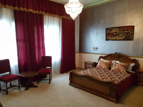 a bedroom with a bed and a chandelier at NF Palace Old City Bucharest in Bucharest