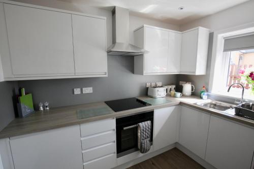a white kitchen with white cabinets and a sink at 24 Old Scapa Road in Kirkwall