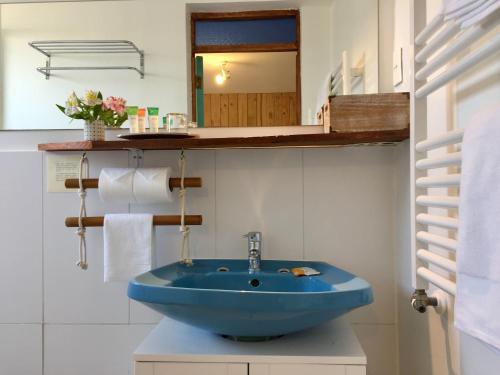 a bathroom with a blue sink and a mirror at Casapapudo Boutique Suites in Papudo