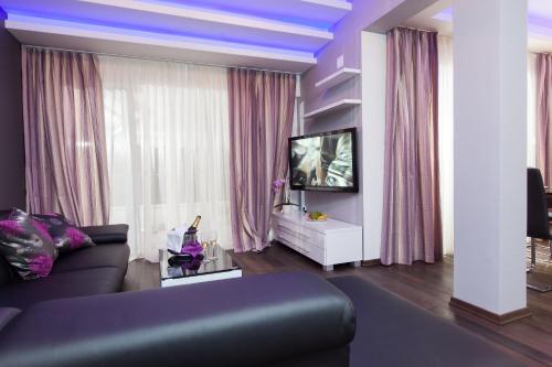 a living room with a couch and a tv at Apartmani Pašalić in Tučepi