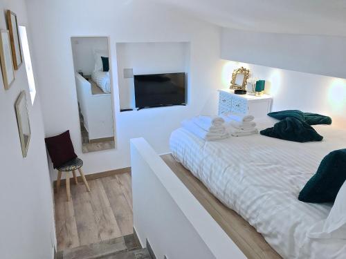 アンティーブにあるAppartement vieil Antibesの白いベッドルーム(ベッド1台、鏡付)