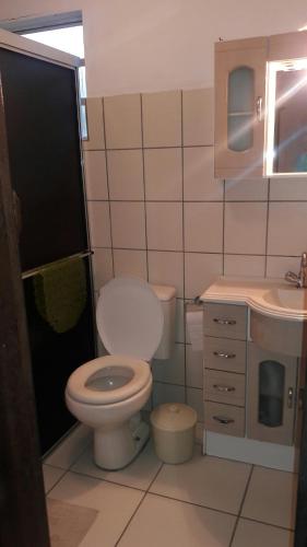a bathroom with a toilet and a sink at Beira mar Mariluz in Imbé