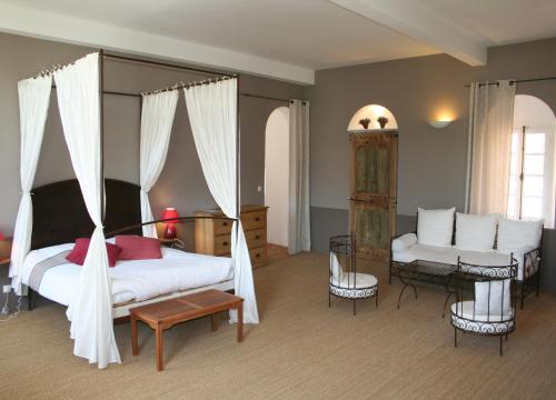 1 dormitorio con 1 cama, 1 silla y 1 sofá en Le Couvent, en Apt