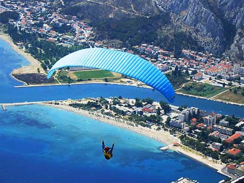 een persoon die met een parachute door de lucht vliegt bij Villa Sladojević in Omiš