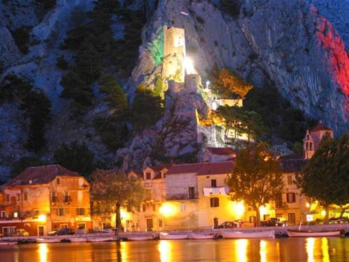 una città con un castello su una montagna di notte di Villa Sladojević a Omiš (Almissa)