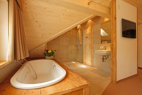 a bathroom with a tub and a sink at Bären - Das Gästehaus in Gais