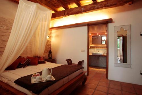 a bedroom with a bed with shoes on it at Can Lluc Boutique Country Hotel & Villas, a member of Beyond Green in Sant Rafael de Sa Creu