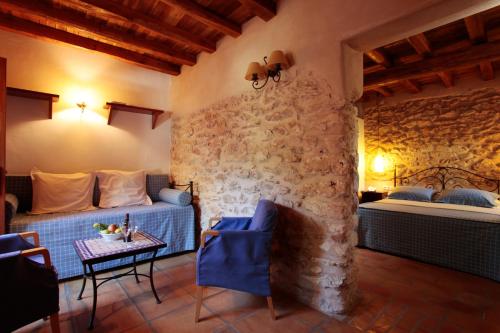 a bedroom with two beds and a table in a room at Can Lluc Boutique Country Hotel & Villas, a member of Beyond Green in Sant Rafael de Sa Creu
