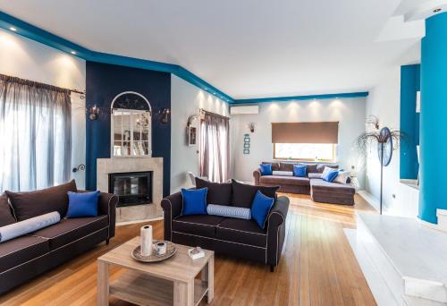 a living room with two couches and a fireplace at Fokas Luxury Villa in Prinos