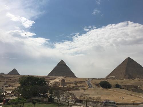 a view of the pyramids of giza under a cloudy sky at Pyramids View Inn in Cairo