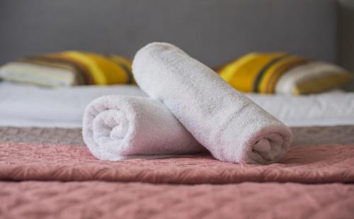a stack of towels sitting on a bed at Apartamenty Centrum in Koszalin