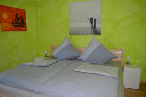 a bedroom with a large bed with green walls at Ferienwohnung Gravemeier in Ladbergen