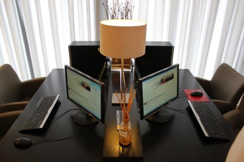 a table with three laptops and a lamp on it at Hotel Principe Lisboa in Lisbon