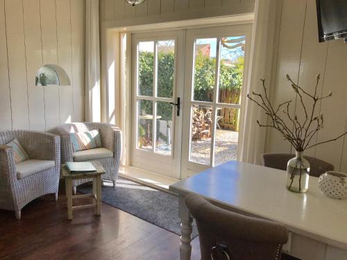 a living room with a table and chairs and a sliding glass door at Het Koetshuis in Kamperland