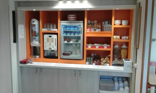 a kitchen with a counter with a refrigerator at Premiere Classe Orleans Ouest - La Chapelle St Mesmin in La Chapelle-Saint-Mesmin