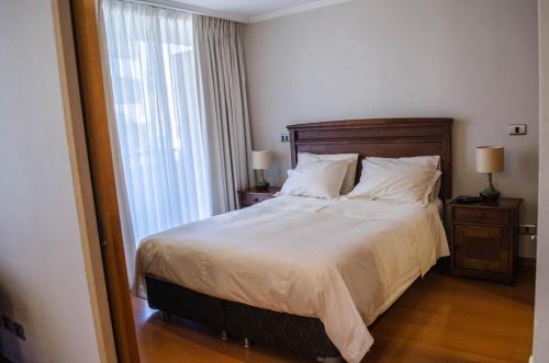 um quarto com uma cama grande e uma janela em Austral Rentahome Diego de Velazquez em Santiago
