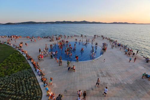 Eine Menschenmenge, die um einen Pool im Wasser steht. in der Unterkunft Apartman Dendo in Zadar