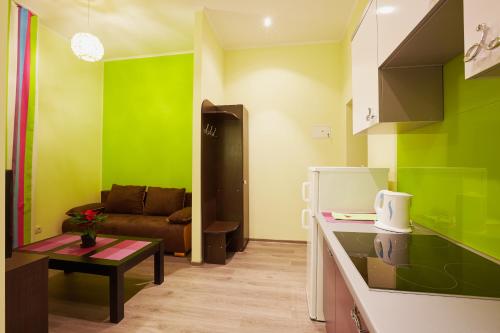 a kitchen with green walls and a couch at Apartment Fedkovycha in Lviv