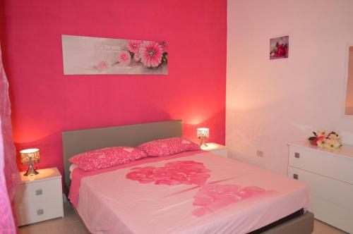 a bedroom with pink walls and a bed with pink pillows at Memmea's House in Specchiolla 