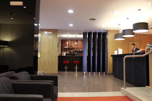a man standing at a bar in a hotel lobby at Hotel Principe Lisboa in Lisbon