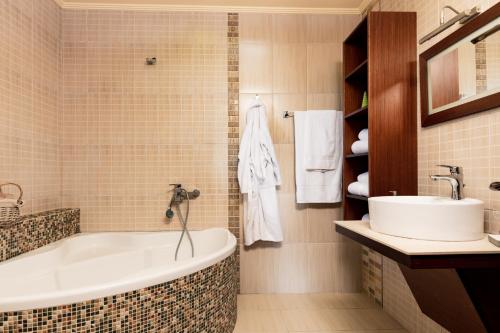 a bathroom with a tub and a sink at Fokas Luxury Villa in Prinos