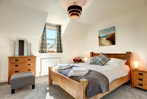 1 dormitorio con 1 cama y 1 silla en Taylor Cottage en St Andrews