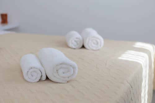 three rolls of towels sitting on top of a bed at PLR Luxury Rooms in Split