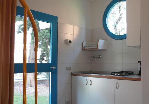 cocina con fregadero y ventana en Casa Sandra Bertolini Alla Spiaggia, en Nago-Torbole