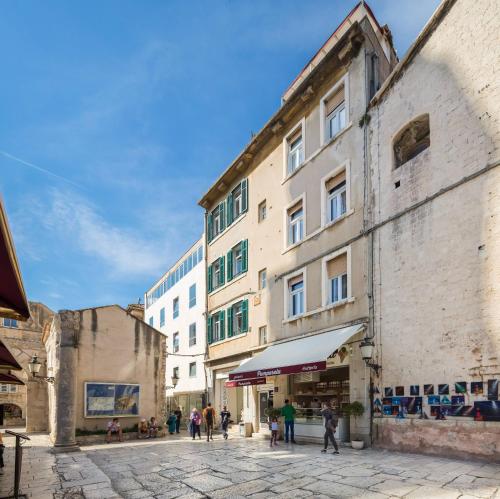 a group of people walking down a street next to a building at PLR Luxury Rooms in Split