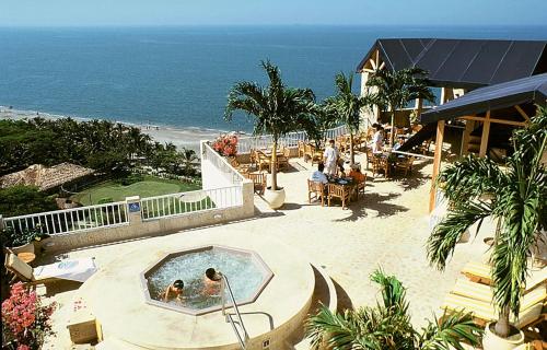 two people in a swimming pool next to the beach at Irotama Resort Zona Torres in Santa Marta