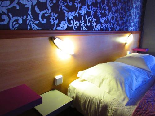 - une chambre avec un lit blanc et une tête de lit en bois dans l'établissement ATCamões, à Almodôvar