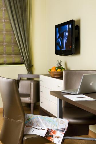 a room with a desk with a laptop and a tv at Opera Garden Hotel & Apartments in Budapest