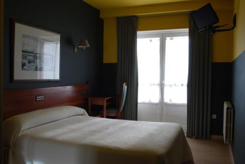 a bedroom with a bed and a sliding glass door at Hotel San Jacobo in Santiago de Compostela