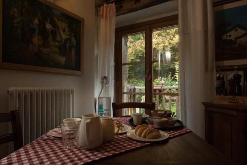 a table with a plate of croissants and a window at Agriturismo L'Eco in Morbegno