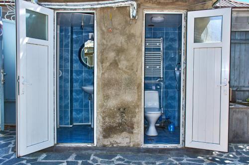 baño con aseo y azulejos azules en Guest House Svetlana, en Gori