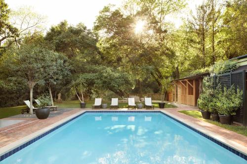 una piscina in un cortile con sedie e alberi di Gaige House a Glen Ellen