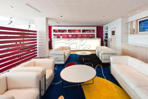 a waiting room with white couches and tables at Hotel Victoria in Roquebrune-Cap-Martin