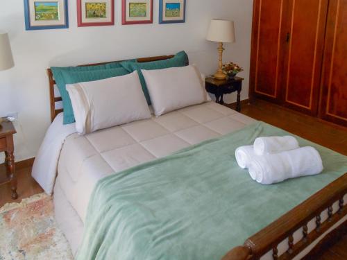 a bedroom with a bed with two towels on it at Casa com 2 Quartos em Serra Negra in Serra Negra
