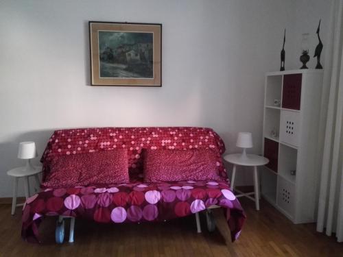 1 dormitorio con cama roja y almohadas rosas en Interno3 en Ancona