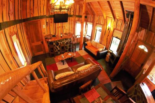 una cabaña de madera con vistas panorámicas a la sala de estar. en Cabañas Tronco Mayen, en Las Trancas