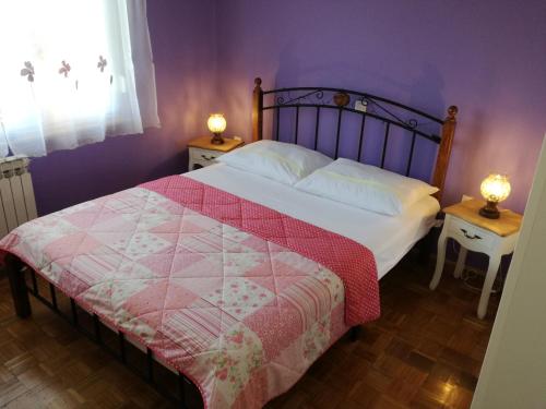 a bedroom with a bed with a red and white quilt at Apartman Sara in Pula