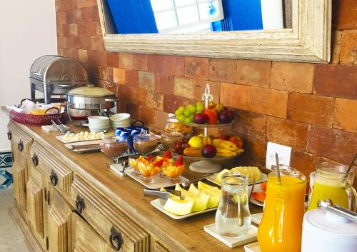 a buffet of fruits and vegetables on a counter at Hotel Solar do Arco in Cabo Frio