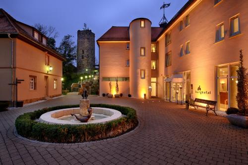 a courtyard with a fountain in the middle of a building at Burghotel Staufeneck in Salach