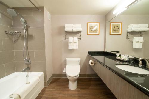 a bathroom with a toilet and a sink and a tub at Miyako Hotel Los Angeles in Los Angeles