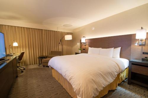 a hotel room with a large bed and a television at Miyako Hotel Los Angeles in Los Angeles