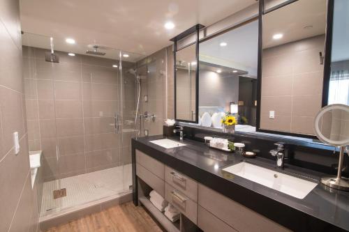 a bathroom with two sinks and a shower and a mirror at Miyako Hotel Los Angeles in Los Angeles