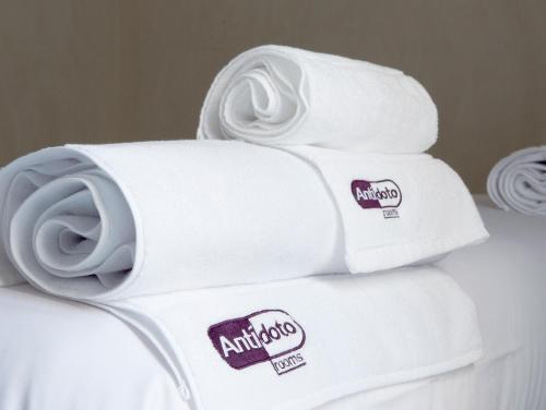a stack of white towels with stickers on them at Antidoto Rooms San Agustín - Recomendado para adultos in Toledo