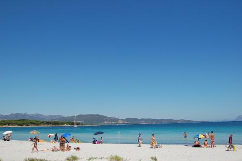 a group of people on a beach with the water at Hotel Budoni Beach in Budoni