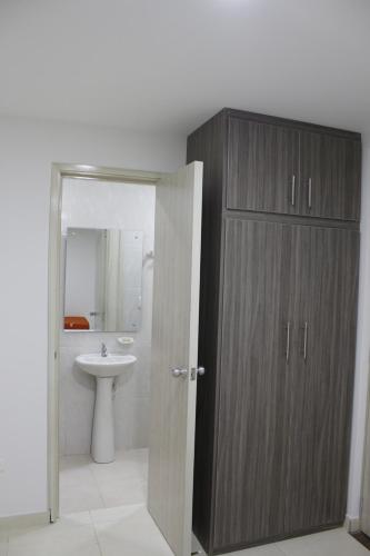 a bathroom with a sink and a wooden cabinet at Hotel Pereira 421 in Pereira