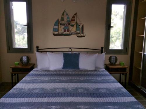 a bedroom with a bed with a blue and white comforter at Maniata Holiday Apartments in Andipáta Erísou